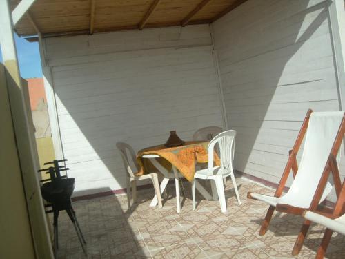 een tafel en stoelen op de achterveranda van een huis bij Apartment Terrace NearThe Beach Medina in Essaouira