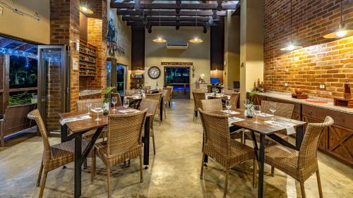 a restaurant with tables and chairs and a brick wall at Nkomazi Kruger Lodge & Spa in Malelane