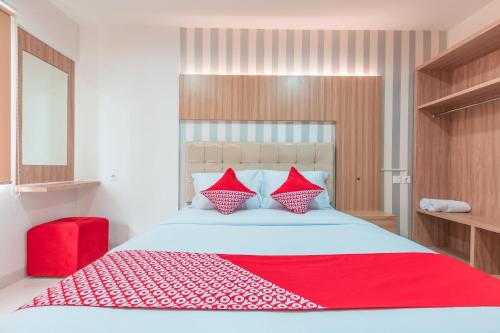 ein Schlafzimmer mit einem großen Bett mit einer roten Decke in der Unterkunft Super OYO 1948 Apartement Sentul Tower in Bogor