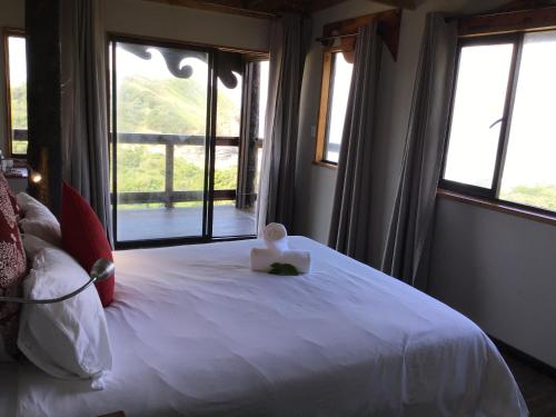 a bedroom with a white bed with a box on it at CORAM DEO SaltyWaves double en-suite rooms with sea views in Coffee Bay