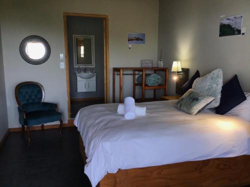 a bedroom with a large bed with a teddy bear on it at CORAM DEO SaltyWaves double en-suite rooms with sea views in Coffee Bay