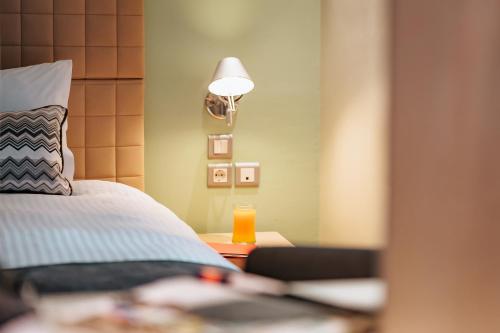 a bedroom with a bed and a table with a lamp at Domotel Olympia in Thessaloniki