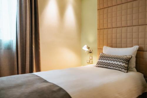 a bedroom with a bed with a pillow and a lamp at Domotel Olympia in Thessaloniki