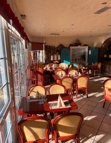 a restaurant with tables and chairs in a room at Hotel Restaurant Germania in Neuwied