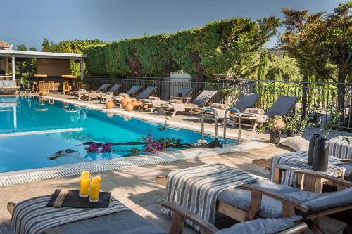 a pool with chaise lounge chairs and a swimming pool at Avithos Resort Hotel in Svoronata