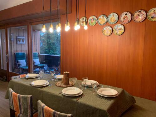 uma mesa de jantar com pratos e copos em Renovated Mountain View Apartment - Les Eperviers em Crans-Montana