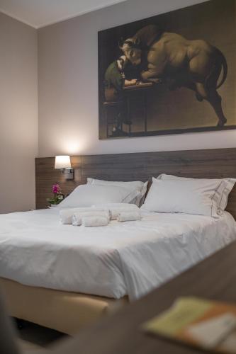 a large white bed with two towels on it at Hotel Guerro in Castelvetro di Modena