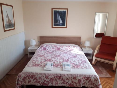 1 dormitorio con 1 cama y 1 silla roja en Apartments Boglić, en Umag