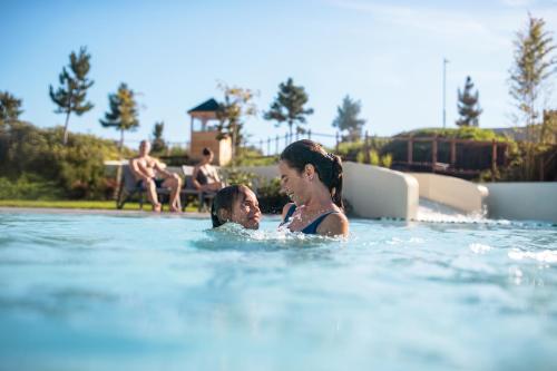 een vrouw en kind in een zwembad bij Center Parcs Park De Haan in De Haan