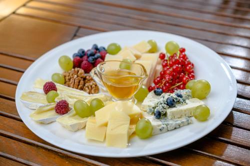 a plate of cheese and fruit on a table at Vila Palace in Caransebeş