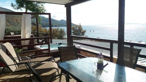 a patio with a table and chairs and a view of the water at Lavanda Mobile Homes & Villas in Orebić