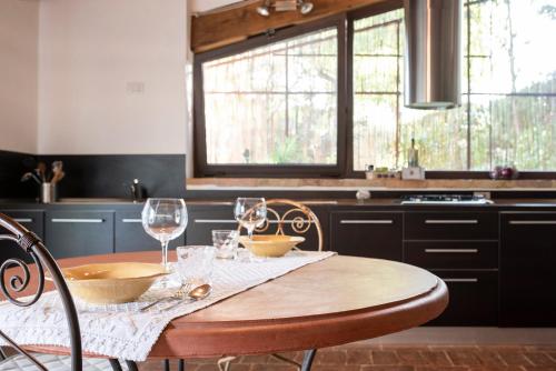 a kitchen with a wooden table with wine glasses on it at Podere Paglieri Apartments in Montespertoli