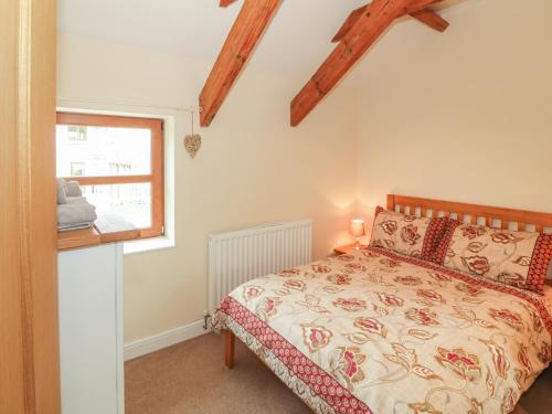 LlandwrogにあるY Beudy Cottageのベッドルーム(ベッド1台、窓付)
