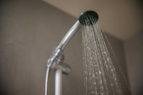 a shower head with water coming out of it at Domotel Olympia in Thessaloniki