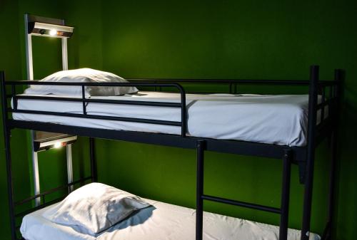2 literas en una habitación con una pared verde en Princess Hostel Leidse Square Amsterdam, en Ámsterdam