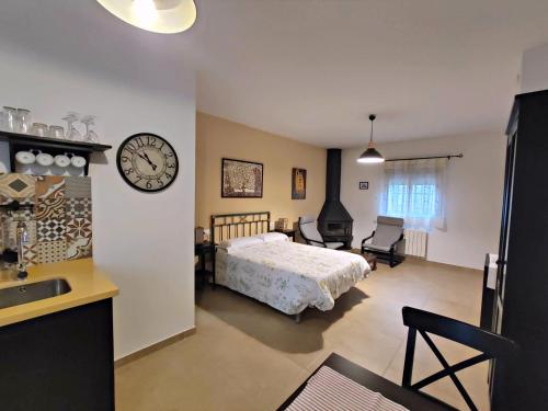 a bedroom with a bed and a clock on the wall at Complejo Apartamentos Rurales Molino de Abajo in Ribera Baja