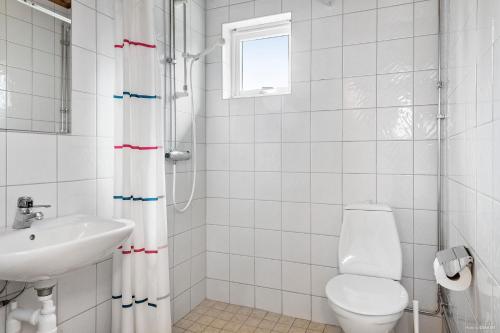 a white bathroom with a toilet and a sink at First Camp Lugnet-Falun in Falun