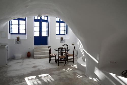 a white room with a table and chairs in it at Aghios Artemios Traditional Houses in Imerovigli