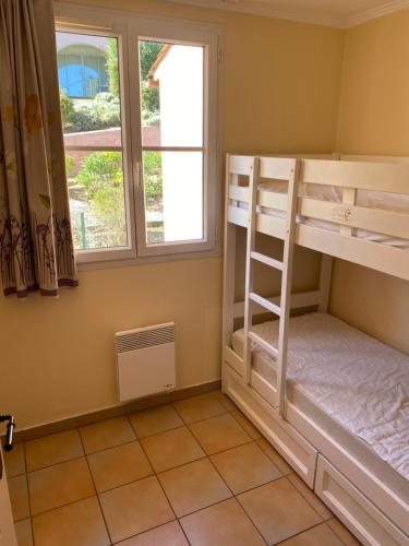 a bedroom with bunk beds and a window at Appartement Les Restanques du Golfe de Saint-Tropez in Grimaud