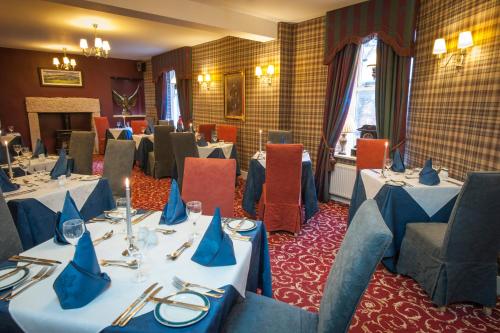 uma sala de jantar com mesas e cadeiras com guardanapos azuis em Loch Kinord Hotel em Dinnet