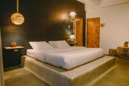a bedroom with a large white bed with a concrete step at SANSE Boutique Hotel in El Nido