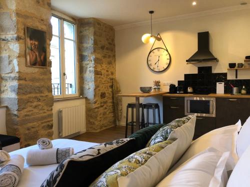 un salon avec un canapé et une horloge au mur dans l'établissement Appartement centre-ville CHIC, à Vannes