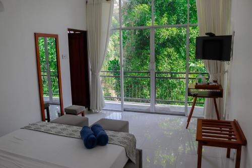 ein Schlafzimmer mit einem Bett und einem großen Fenster in der Unterkunft Hill Country Villa in Kandy
