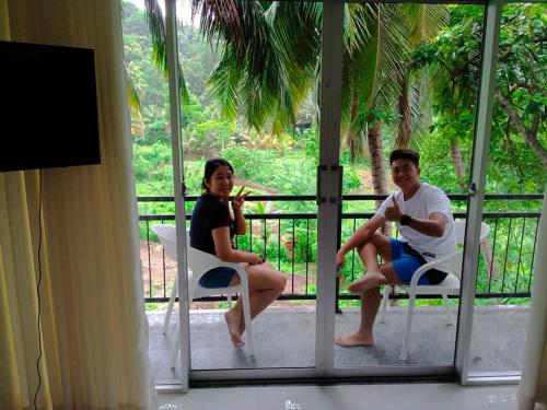 a man and a woman sitting in chairs on a porch at Hill Country Villa in Kandy