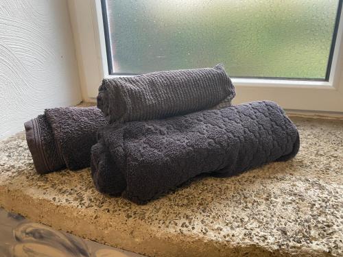 a pile of towels sitting on a counter next to a window at Eifelstein, Apartment mit Whirlpool und Ofen in Dahlem