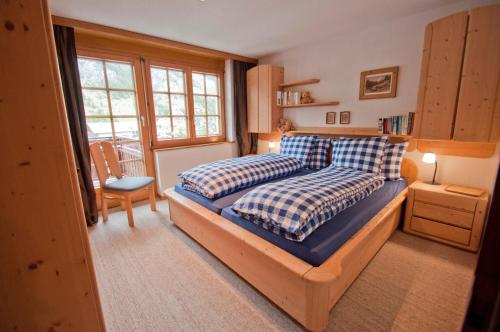 a bedroom with a bed with blue and white pillows at Haus Lizi, Apartment 8 in Zermatt