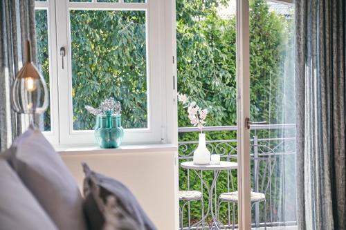 a room with a window and a table with a vase at BUITERLING Hotel in Brilon