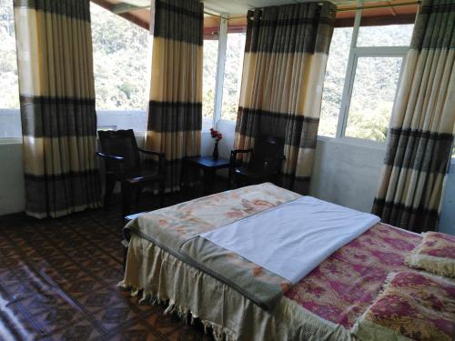 a bedroom with a bed in a room with windows at Cool Mount Guest in Nuwara Eliya