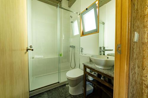 a bathroom with a shower and a toilet and a sink at Albergaria da Tomásia in Aldeia do Meco