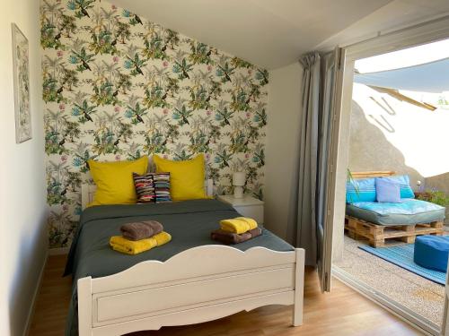 a bedroom with a bed with yellow pillows at Maison Gecko in Ornaisons