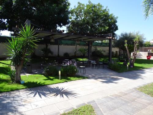 a patio with a table and chairs under a pergola at La casetta al maneggio in Catania