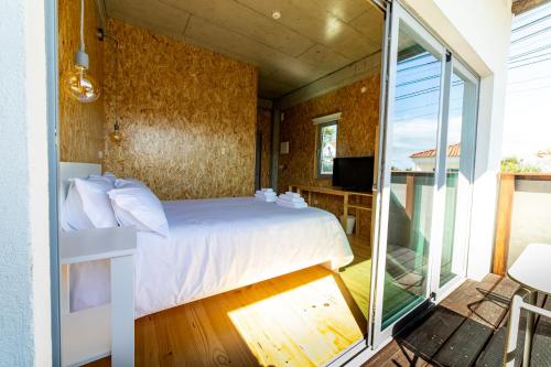 ein Schlafzimmer mit einem Bett und einem Balkon in der Unterkunft Albergaria da Tomásia in Aldeia do Meco