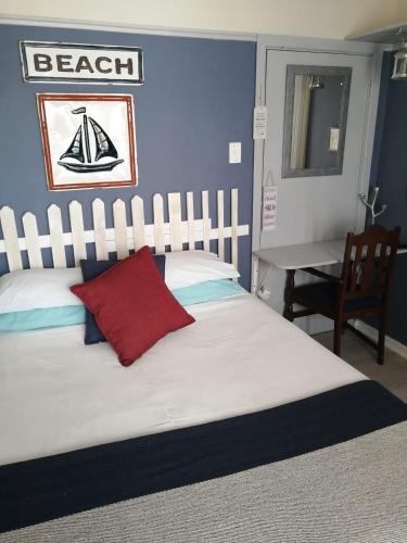 a bedroom with a large white bed with a red pillow at 36 Mount Road Guesthouse and Self Catering in Port Elizabeth