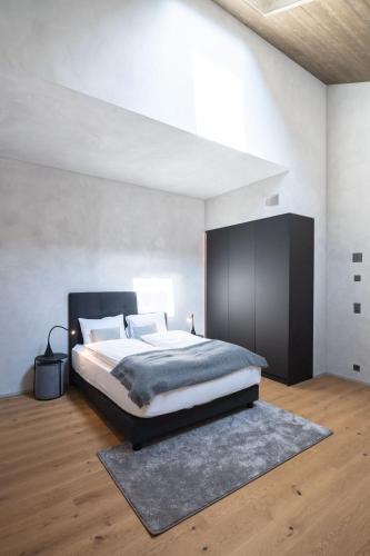 a bedroom with a large bed with a black headboard at Andermatt Alpine Apartments in Andermatt