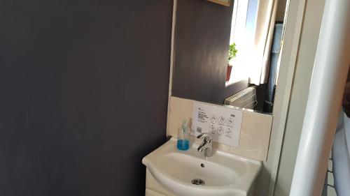 a small bathroom with a sink and a mirror at Hour Glass Hotel in London