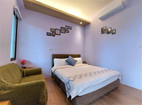 a bedroom with a bed and a chair at Dosun B&B in Jiufen
