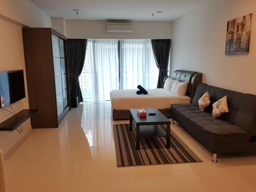 sala de estar con cama y sofá en Summer Suites Studios, en Kuala Lumpur