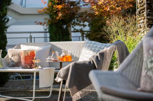 a patio with a table and chairs with towels on it at hirschen dornbirn - das boutiquestyle hotel - skyrelax & wellness im rooftop in Dornbirn