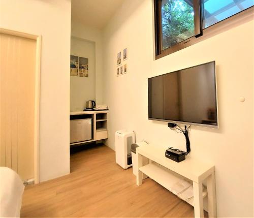 a living room with a large flat screen tv on the wall at Dosun B&B in Jiufen