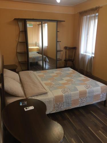 a bedroom with a bed with a mirror and a chair at Апартаменты в центре с парковкой in Cherkasy