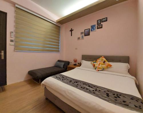 a bedroom with a large bed and a chair at Dosun B&B in Jiufen