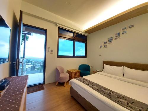 a bedroom with a bed and a desk and windows at Dosun B&B in Jiufen