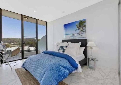 a bedroom with a bed and a view of the ocean at Stylish Penthouse with Views & Jacuzzi in Gosford