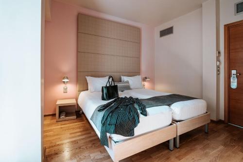 a bedroom with a bed with a purse on it at Domotel Olympia in Thessaloniki