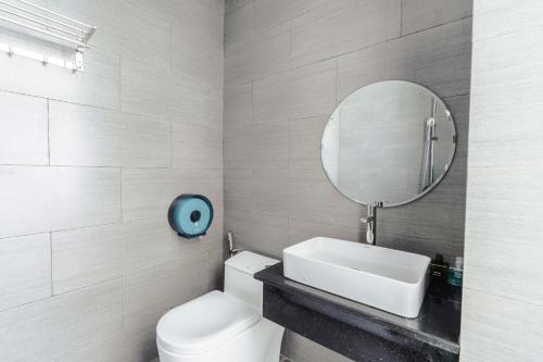 een badkamer met een wit toilet en een spiegel bij Đà Lạt Mega Sky Hotel in Da Lat