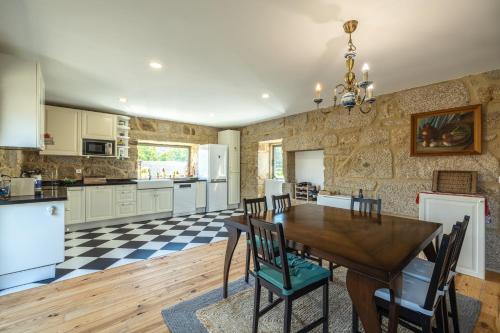 a large kitchen with a wooden table and chairs at Casa da Veiga in Aldeia